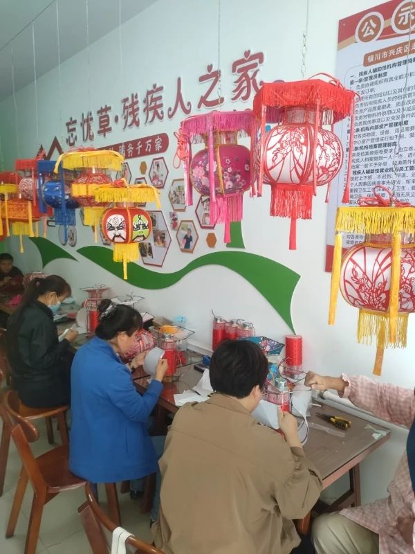 图为银川市兴庆区忘忧草残疾人之家组织残疾人制作花灯